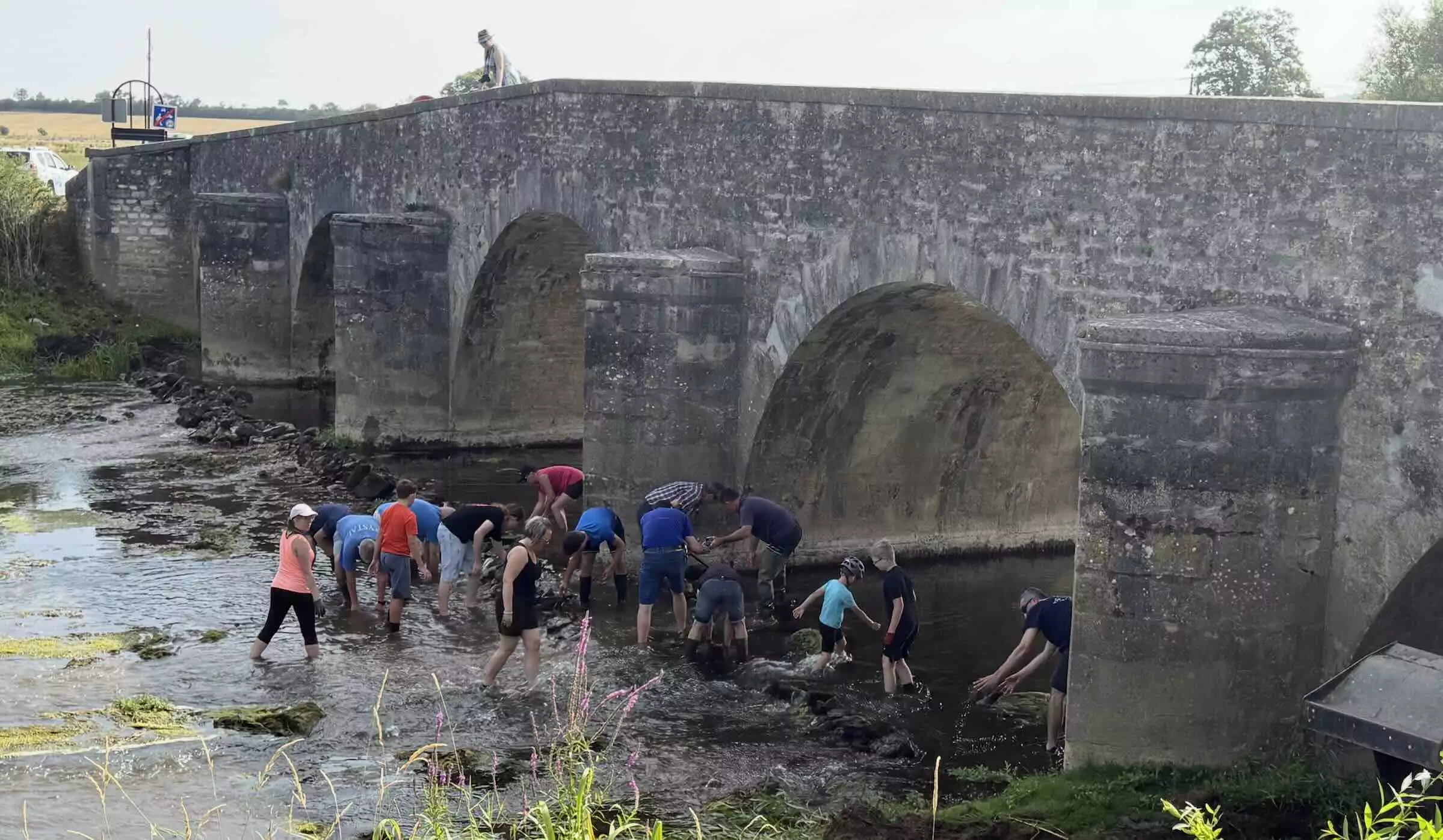 Les volontaires œuvrant à la remise en eau des pieux du pont sur le Meuse datant d’avant la Révolution © R. Lecocq