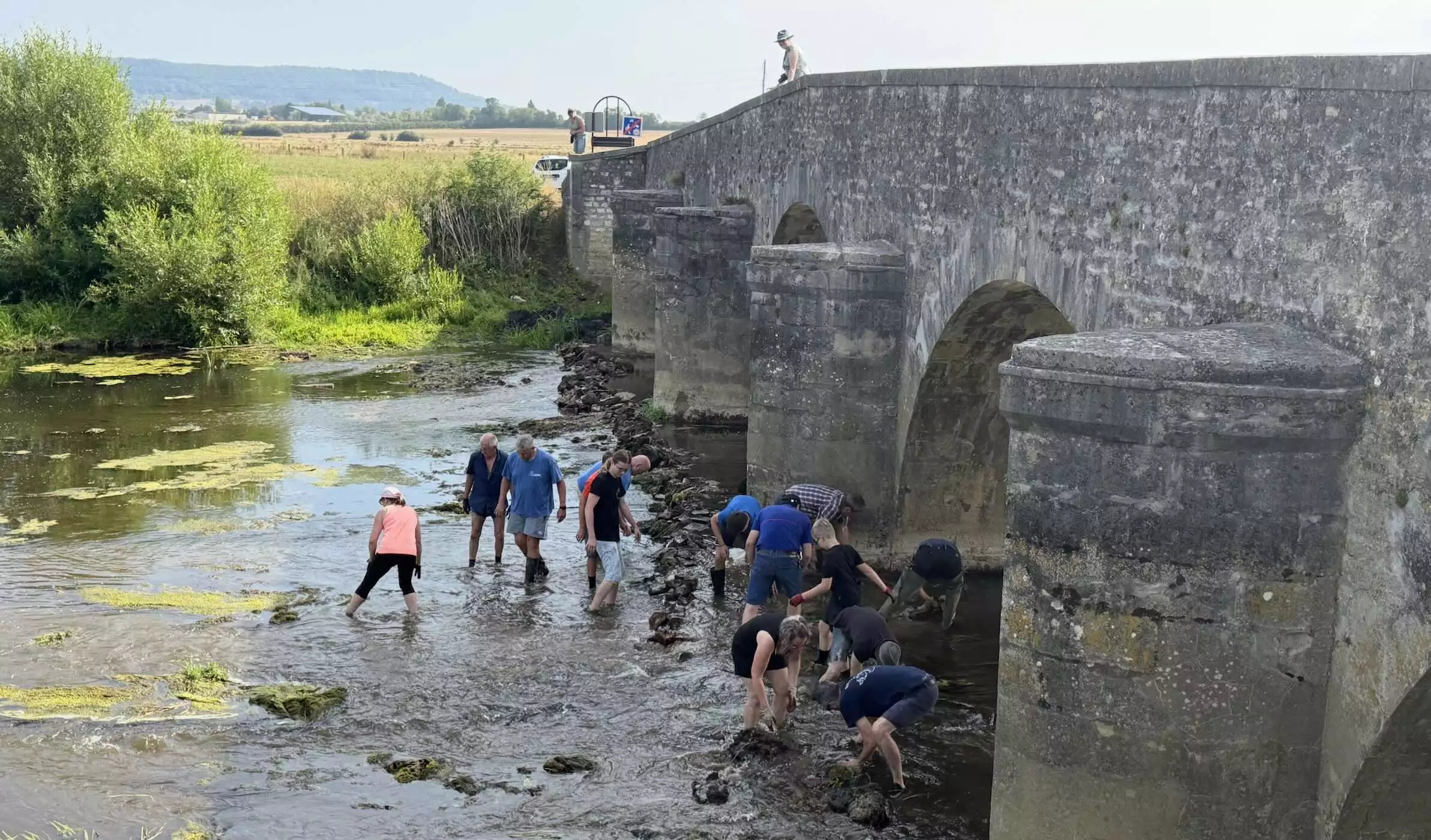 Les volontaires œuvrant à la remise en eau des pieux du pont sur le Meuse datant d’avant la Révolution © R. Lecocq